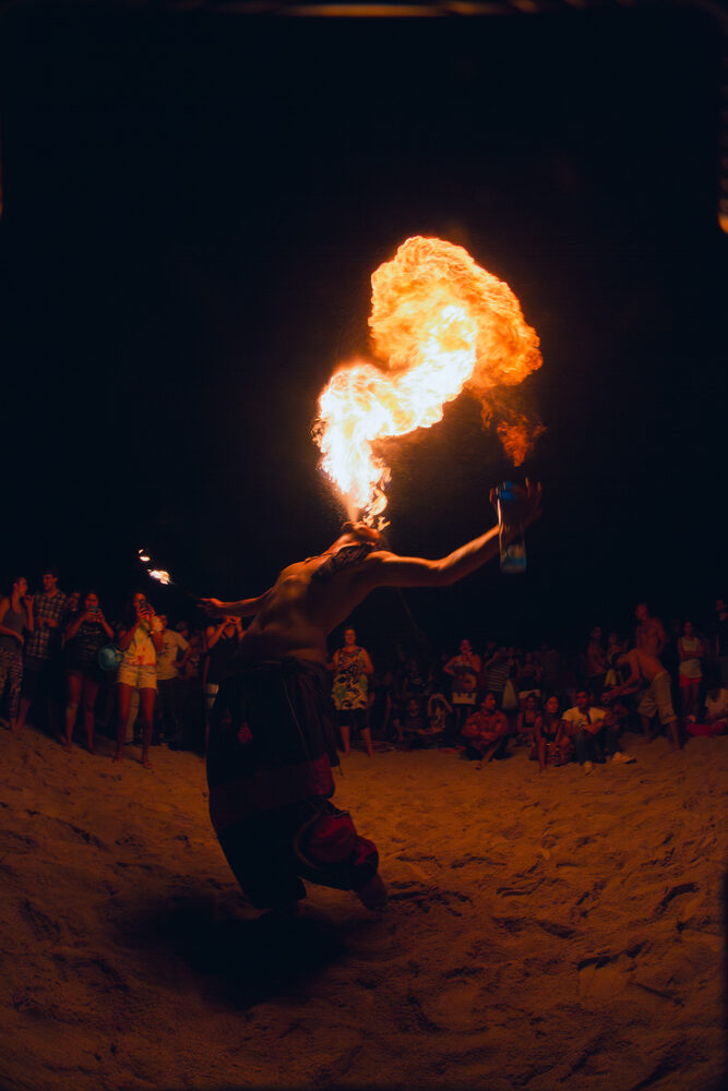 Cuspidor de fogo em performance noturna na praia