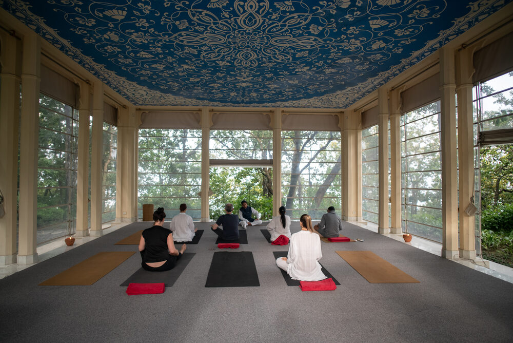 Aula de yoga em pavilhão com teto ornamentado